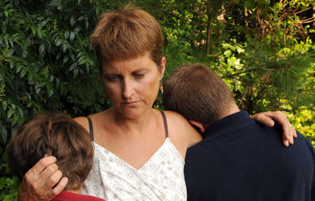 Woman comforts young boys