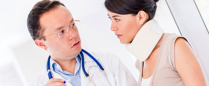 Doctor speaks with female patient in neck brace